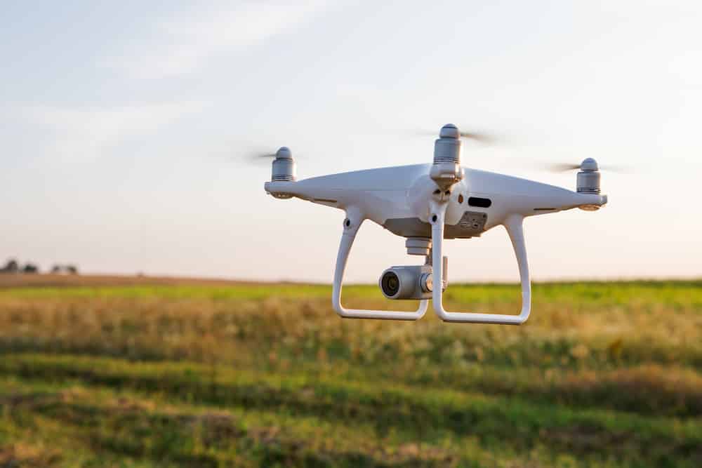White drone flying over field