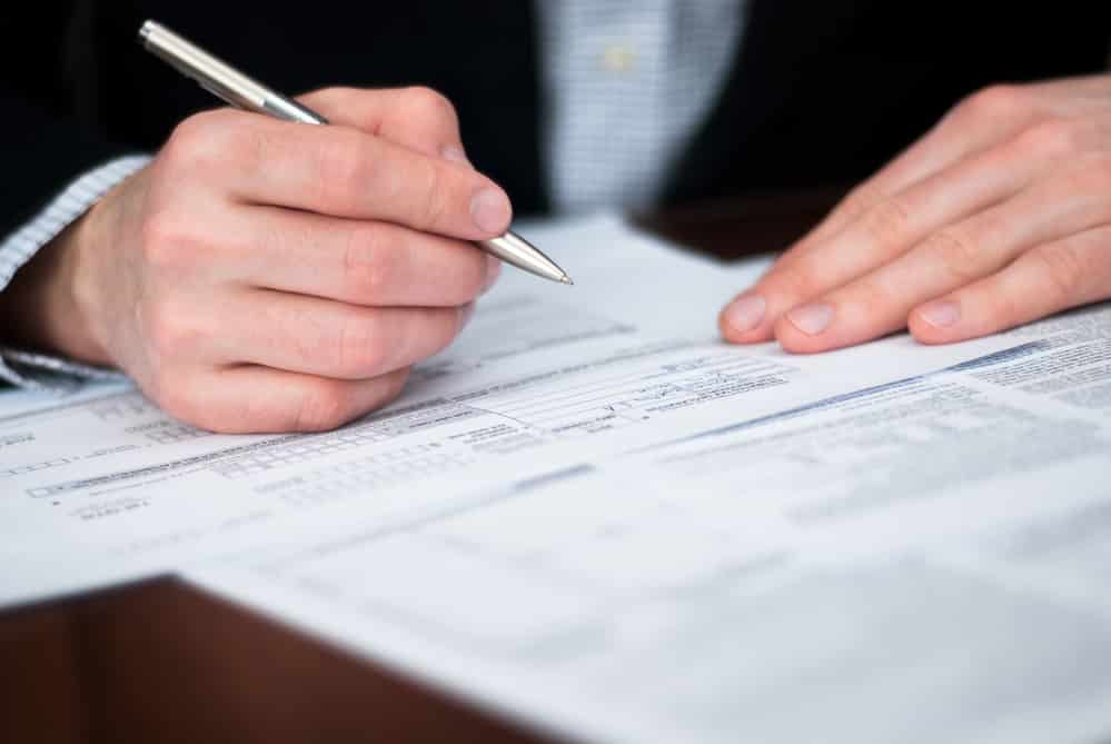 Close-up of businessman's hands filling out forms