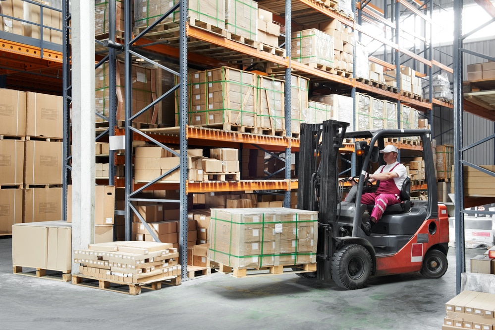 Forklift operator in manufacturing facility, moving boxes